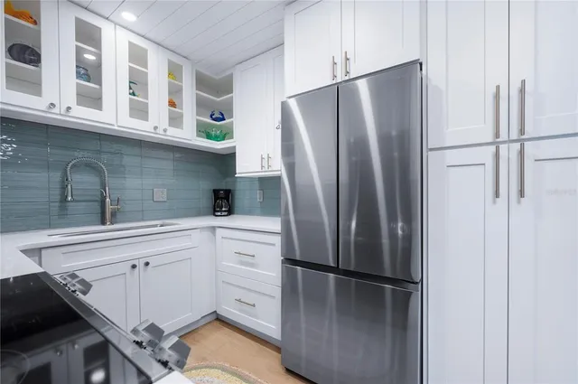 a kitchen with stainless steel appliances a refrigerator sink and cabinets