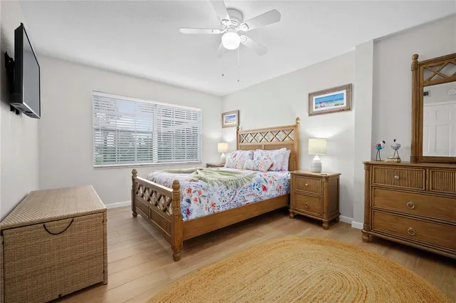 a bedroom with a bed and a flat tv screen on dresser