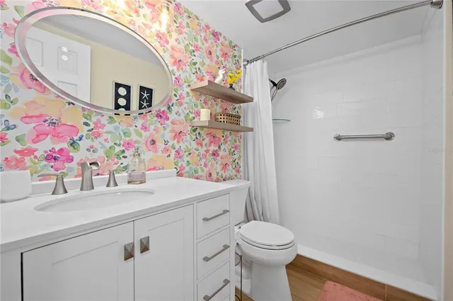 a bathroom with a sink mirror vanity and toilet