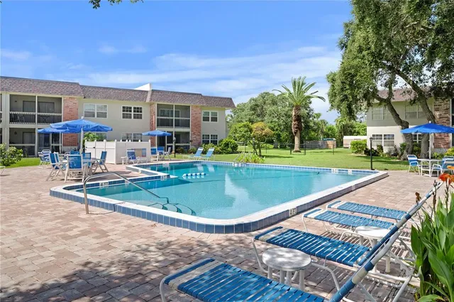 a view of a house with a swimming pool and sitting area
