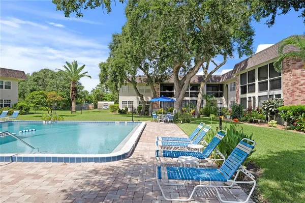 a view of a house with swimming pool and sitting area