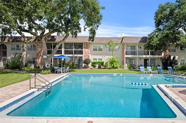 a swimming pool view with a seating space and a garden view
