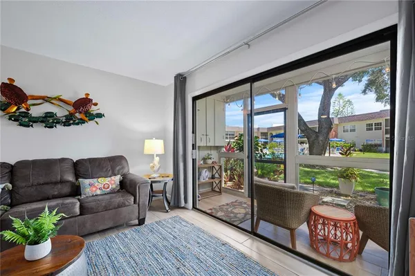 a living room with furniture and a large window with wooden floor