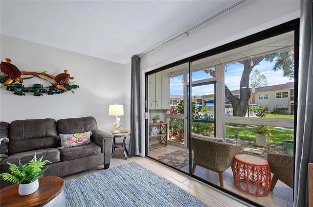 a living room with furniture and a large window with wooden floor
