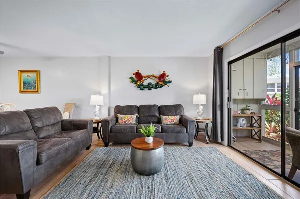 a living room with furniture kitchen view and a large window