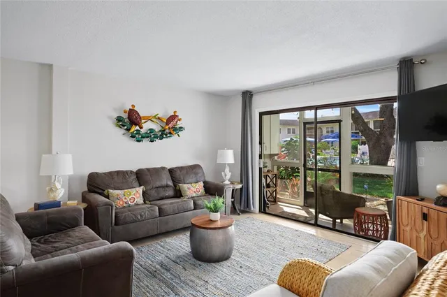 a living room with furniture a flat screen tv and a floor to ceiling window