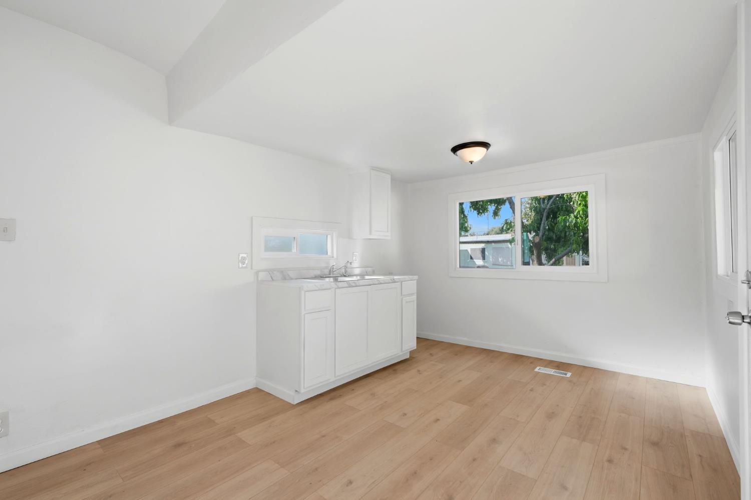 715 South Kaweah Avenue, Unit 9 Exeter, CA 93221 - Photo 14 of 15 an empty room with a wooden floor and windows