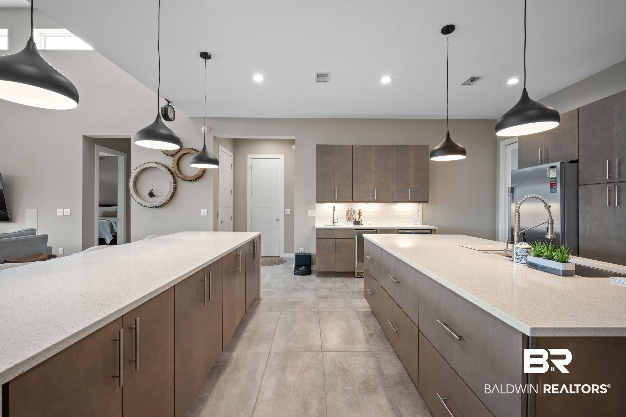 3840 Cotton Way Orange Beach, AL 36561 - Photo 15 of 75 Kitchen with light stone countertops, a large island, backsplash, stainless steel fridge, and decorative light fixtures