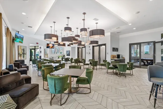 a very nice looking dining room with kitchen island stainless steel appliances lots of white furniture