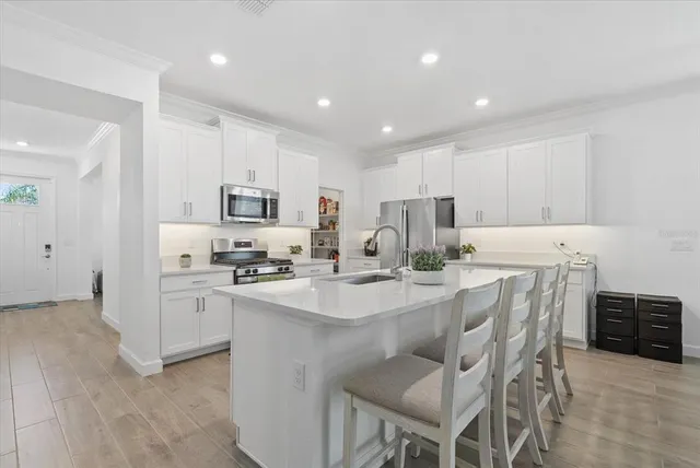 a kitchen with white cabinets and stainless steel appliances