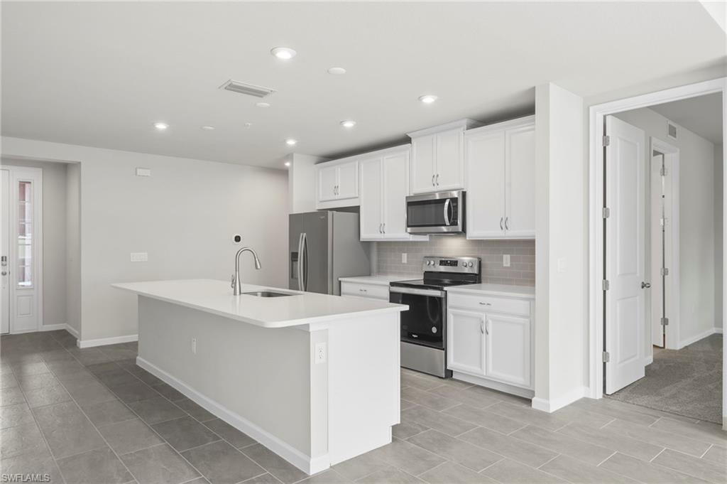 4664 Arboretum Circle, Unit 102 Naples, FL 34112 - Photo 19 of 39 a kitchen with stainless steel appliances a sink stove and refrigerator