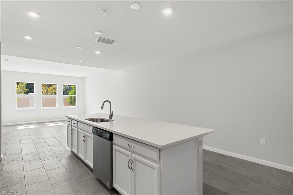 4664 Arboretum Circle, Unit 102 Naples, FL 34112 - Photo 22 of 39 a kitchen with a sink cabinets and window