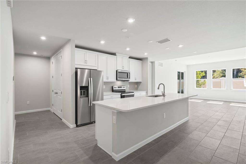 4664 Arboretum Circle, Unit 102 Naples, FL 34112 - Photo 23 of 39 a kitchen with stainless steel appliances a refrigerator sink and microwave
