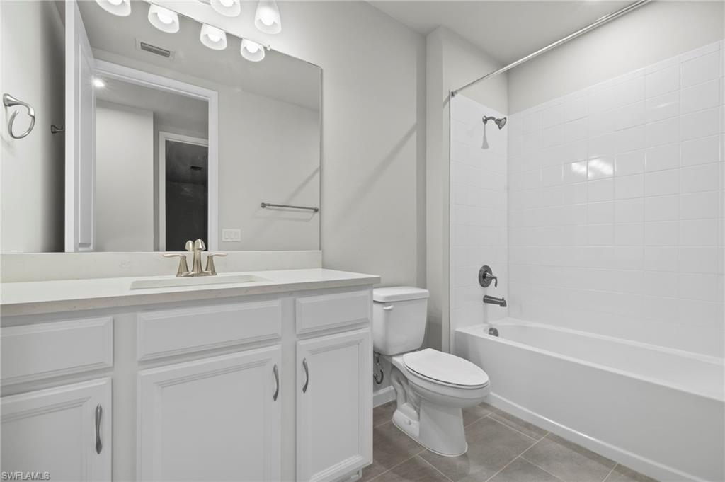 4664 Arboretum Circle, Unit 102 Naples, FL 34112 - Photo 36 of 39 a bathroom with a toilet sink a mirror and shower