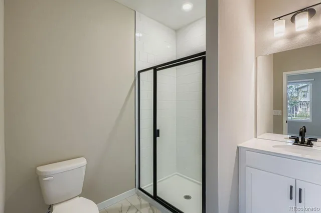 a kitchen with a refrigerator a sink and white cabinets