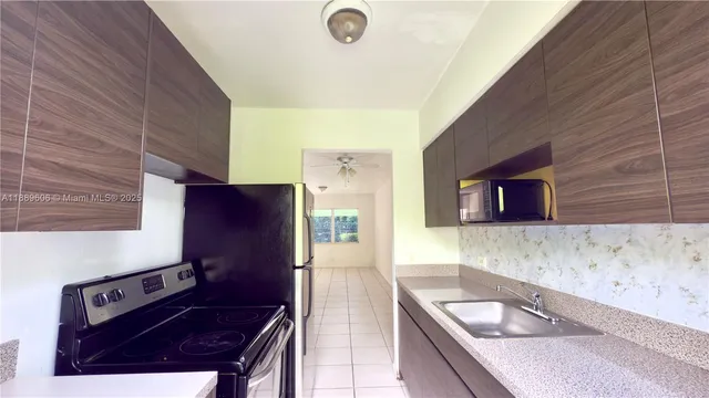 a kitchen with granite countertop a sink stove and refrigerator