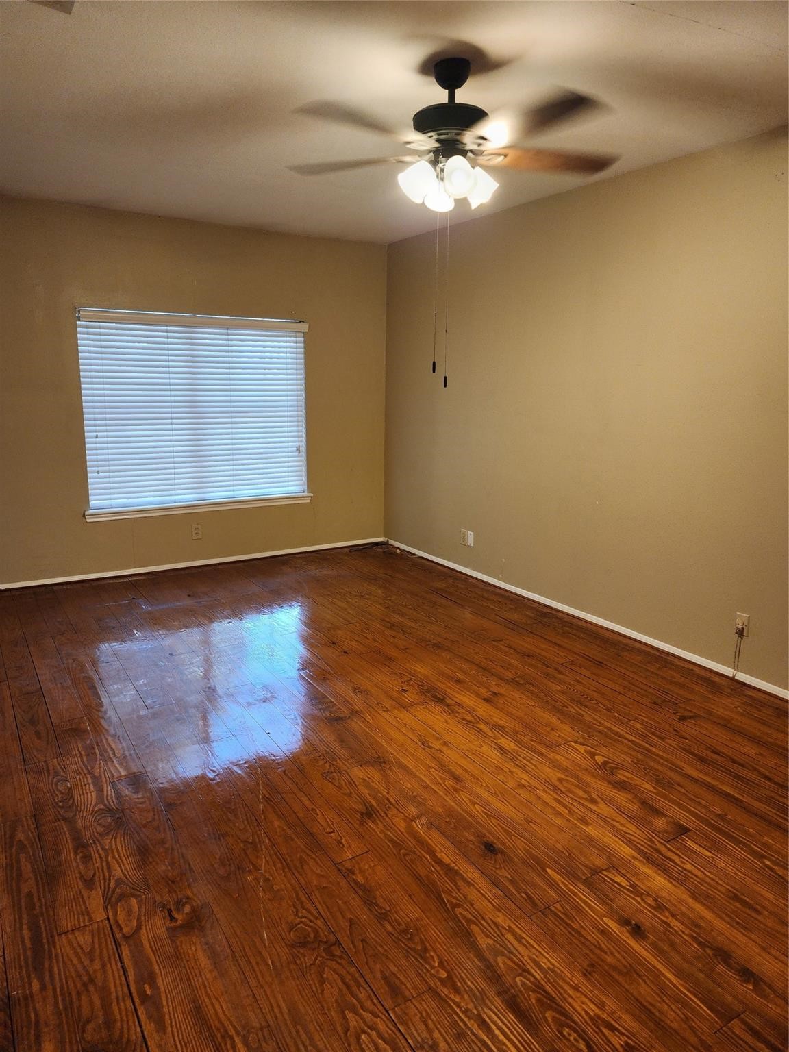7399 Regency Square Court, Unit 7399 Houston, TX 77036 - Photo 11 of 27 a view of empty room with wooden floor and fan