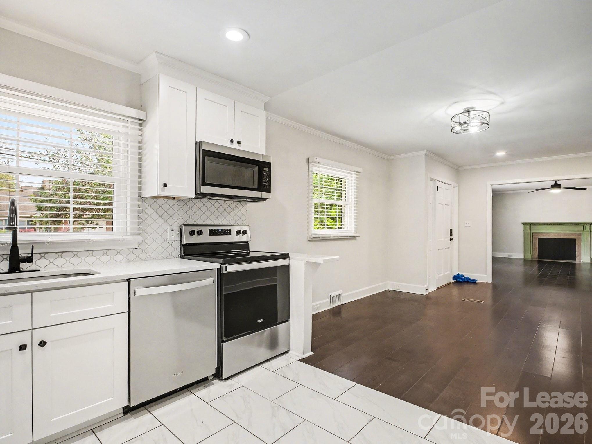 782 Union Street South Concord, NC 28025 - Photo 13 of 28 a kitchen with granite countertop a stove a sink and a microwave