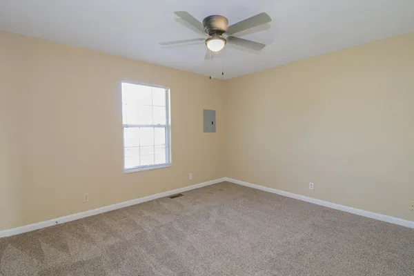 an empty room with a window and a fan