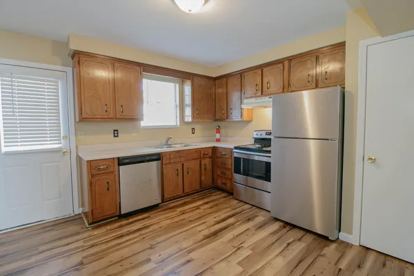 a kitchen with granite countertop stainless steel appliances a refrigerator sink and microwave