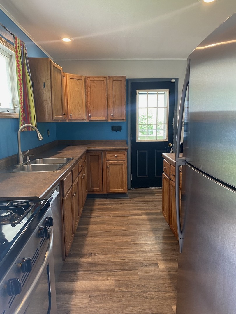614 North Reed Street Joliet, IL 60435 - Photo 14 of 16 a kitchen with stainless steel appliances granite countertop a refrigerator a sink dishwasher a stove and white countertops with wooden floor