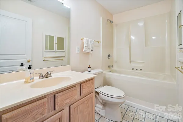 a bathroom with a sink a toilet a mirror and shower