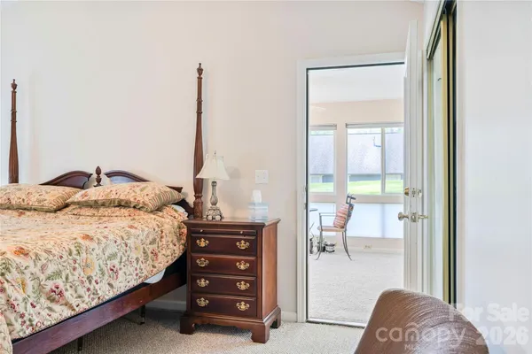 a bedroom with a bed and a dresser next to a window