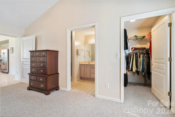 a view of walk in closet and bedroom