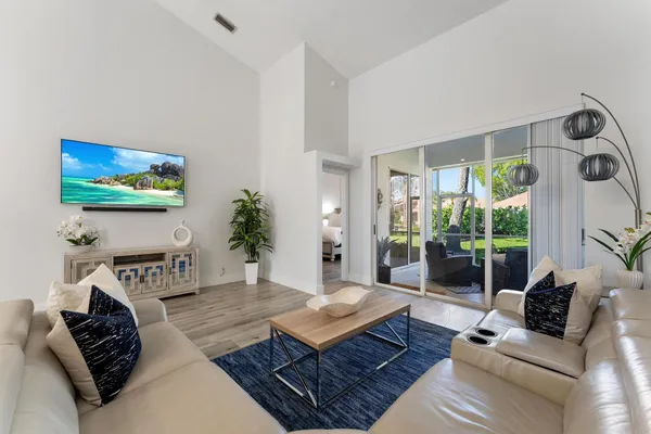 a living room with furniture a flat screen tv and a large window