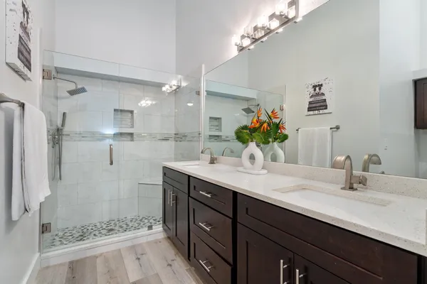 a bathroom with a double vanity sink mirror and shower