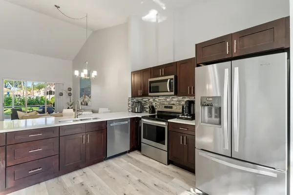 a kitchen with stainless steel appliances granite countertop a stove refrigerator sink and microwave