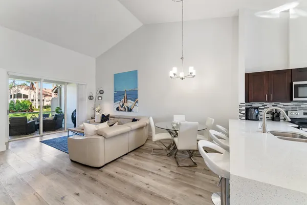 a living room with furniture a chandelier and a flat screen tv