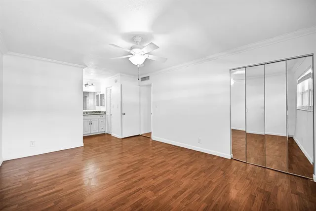 an empty room with wooden floor and window