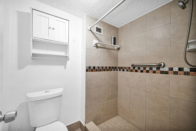 a bathroom with a toilet and a shower