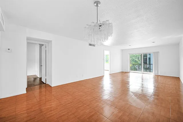 a view of a room with wooden floor large windows and a chandelier