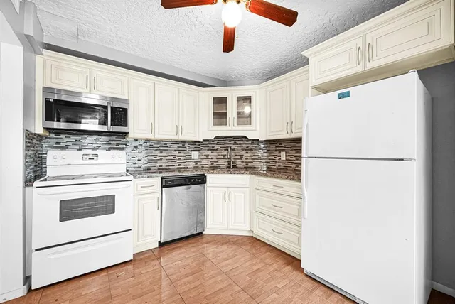 a kitchen with a refrigerator stove and microwave