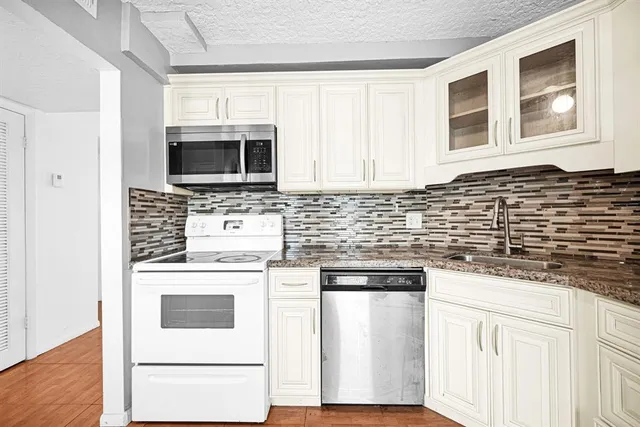a kitchen with stainless steel appliances granite countertop a stove sink microwave and cabinets