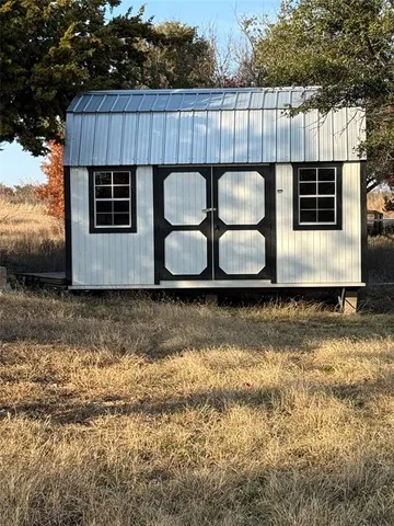a view of a backyard with plants and wooden fence