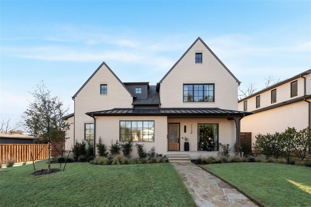 View of front of custom-built contemporary house with a porch and a standing seam roof