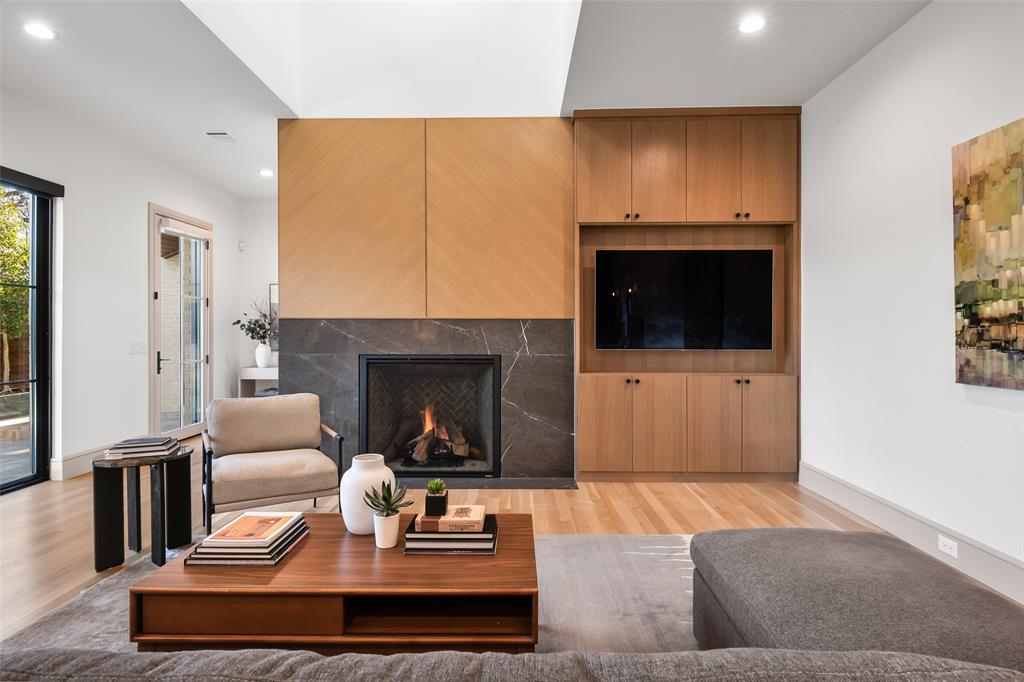 7158 Pasadena Avenue Dallas, TX 75214 - Photo 5 of 39 Living room with light wood-style flooring, recessed lighting, and a lit fireplace
