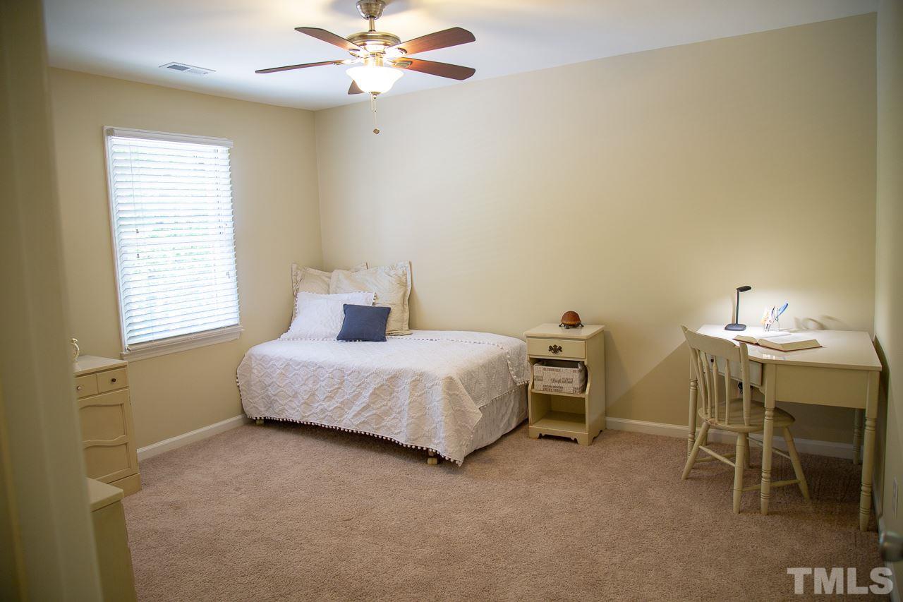 5613 Hamstead Crossing Raleigh, NC 27612 - Photo 12 of 20 a bedroom with a bed and a chandelier