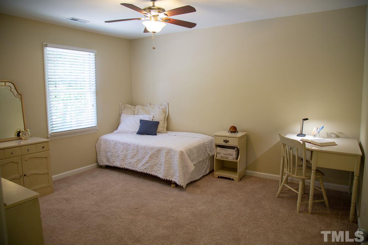 5613 Hamstead Crossing Raleigh, NC 27612 - Photo 14 of 20 a bedroom with a bed and a table chair