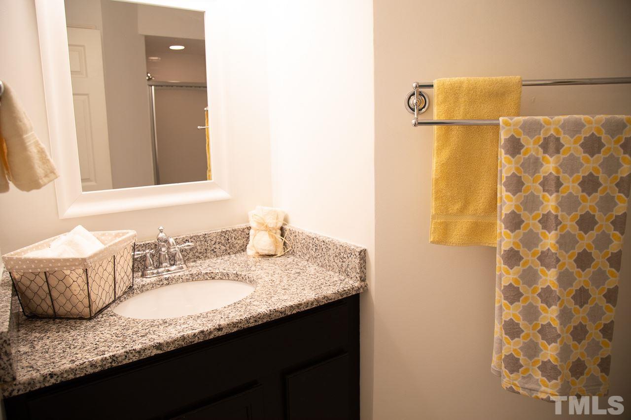 5613 Hamstead Crossing Raleigh, NC 27612 - Photo 16 of 20 a bathroom with a granite countertop sink and a mirror