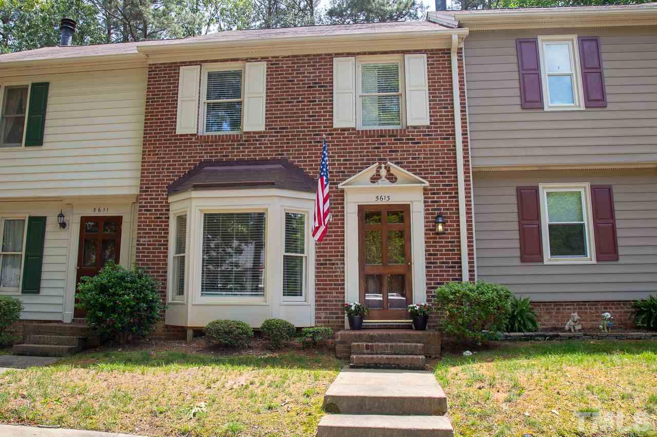 5613 Hamstead Crossing Raleigh, NC 27612 - Photo 17 of 20 a view of a brick house with a yard plants and large tree