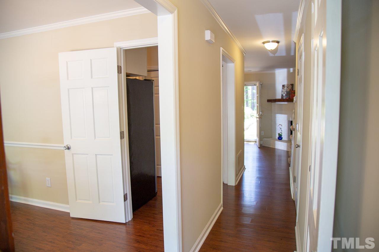 5613 Hamstead Crossing Raleigh, NC 27612 - Photo 4 of 20 a view of a hallway with wooden floor and a bathroom