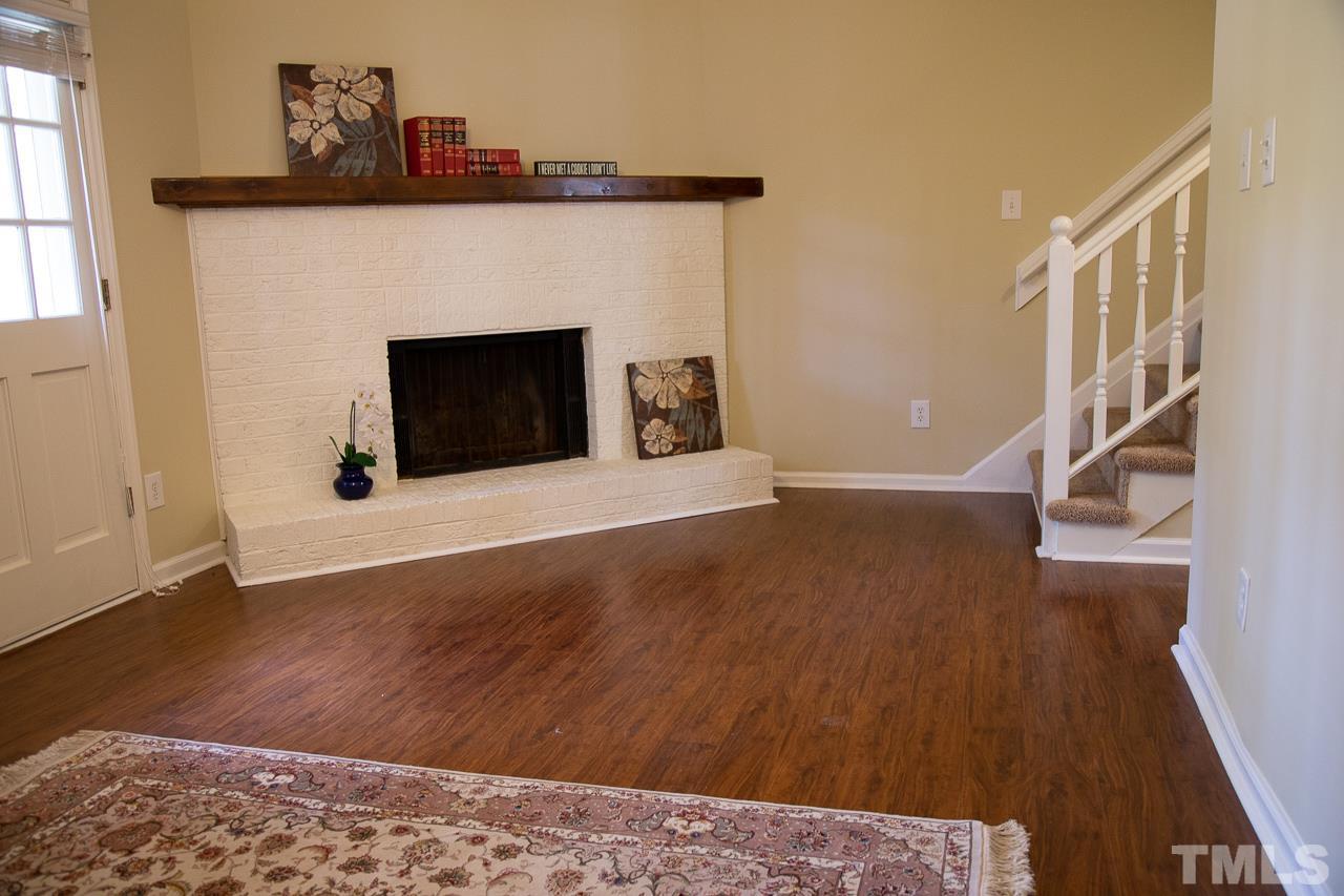 5613 Hamstead Crossing Raleigh, NC 27612 - Photo 5 of 20 a view of a livingroom with wooden floor and a fireplace