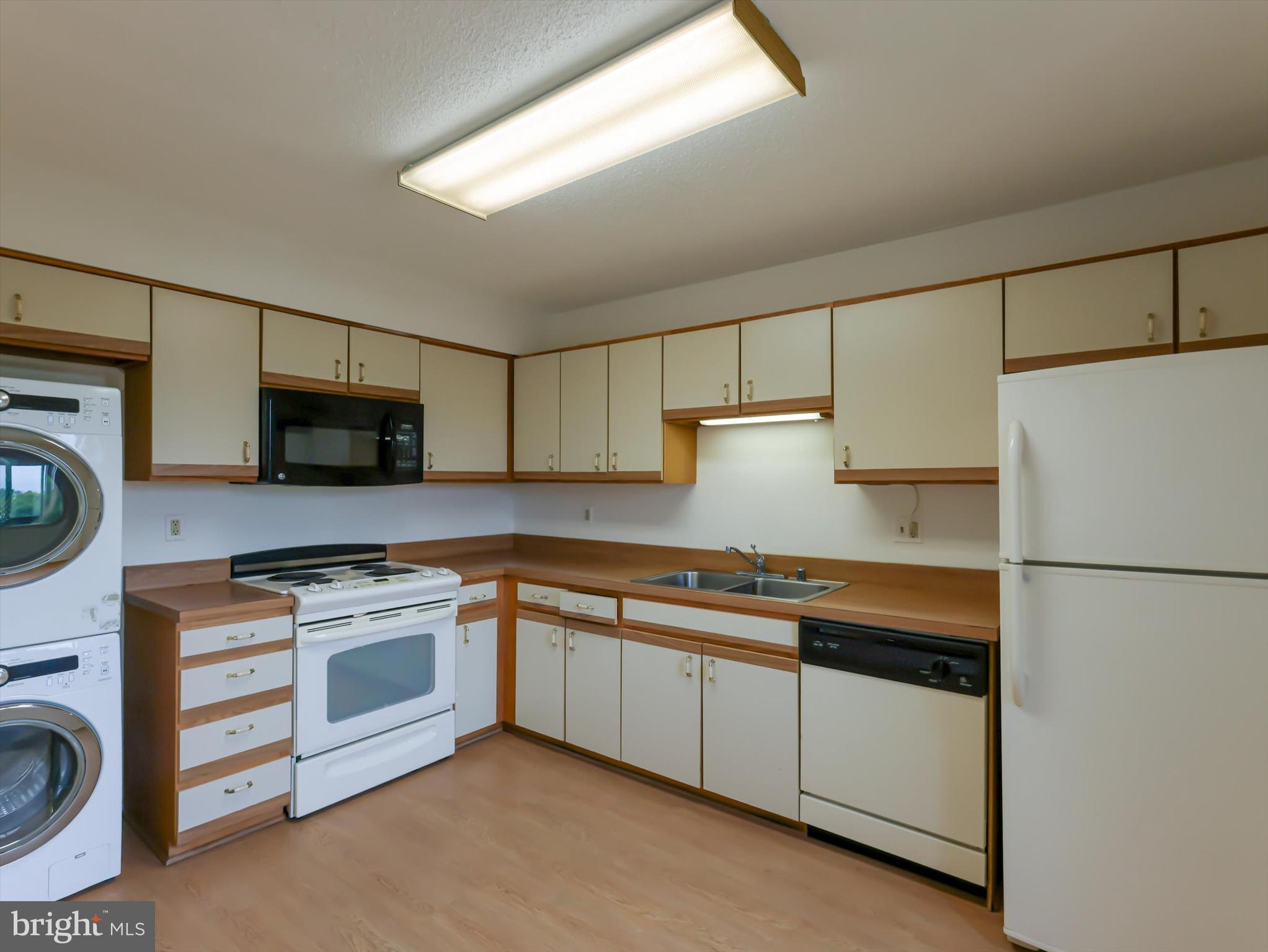 15115 Interlachen Drive, Unit 31012 Silver Spring, MD 20906 - Photo 8 of 35 a kitchen with stainless steel appliances white cabinets and a refrigerator