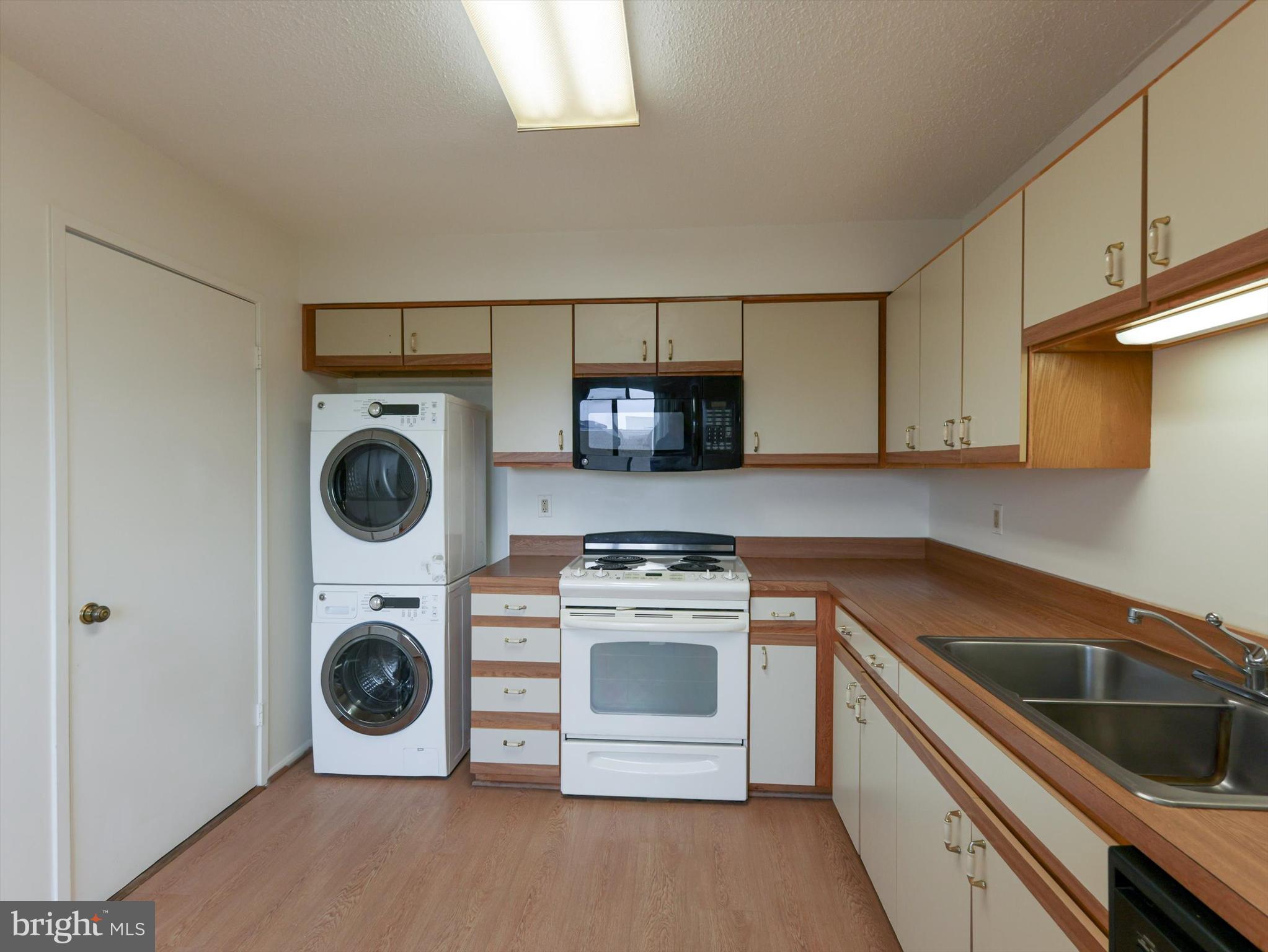 15115 Interlachen Drive, Unit 31012 Silver Spring, MD 20906 - Photo 9 of 35 a kitchen with a stove top oven and cabinets