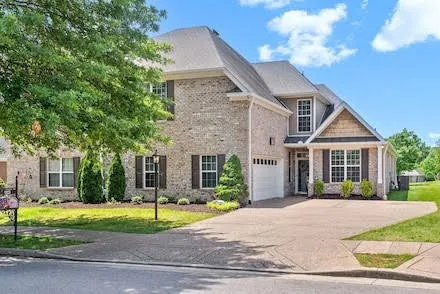 a front view of a house with a yard and potted plants