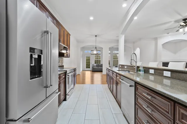 a large kitchen with stainless steel appliances lots of counter space and wooden floor